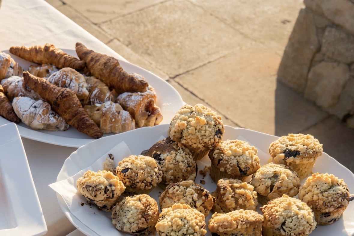 Homemade muffins, croissants and pastries on a white platter