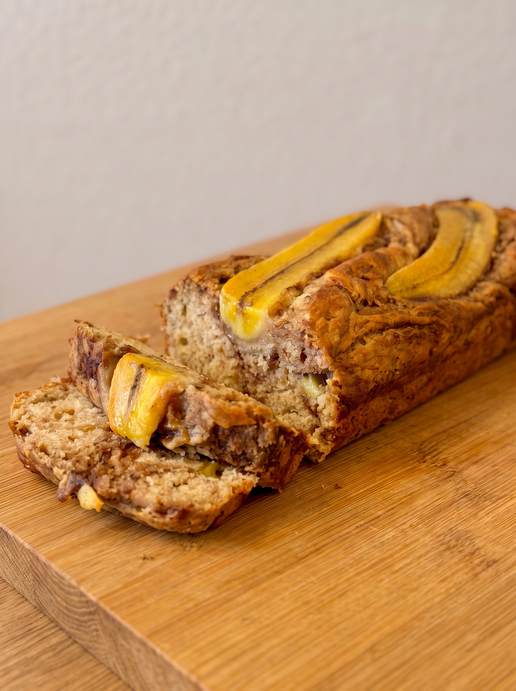 Homemade banana bread with caramelised banana on a wooden board